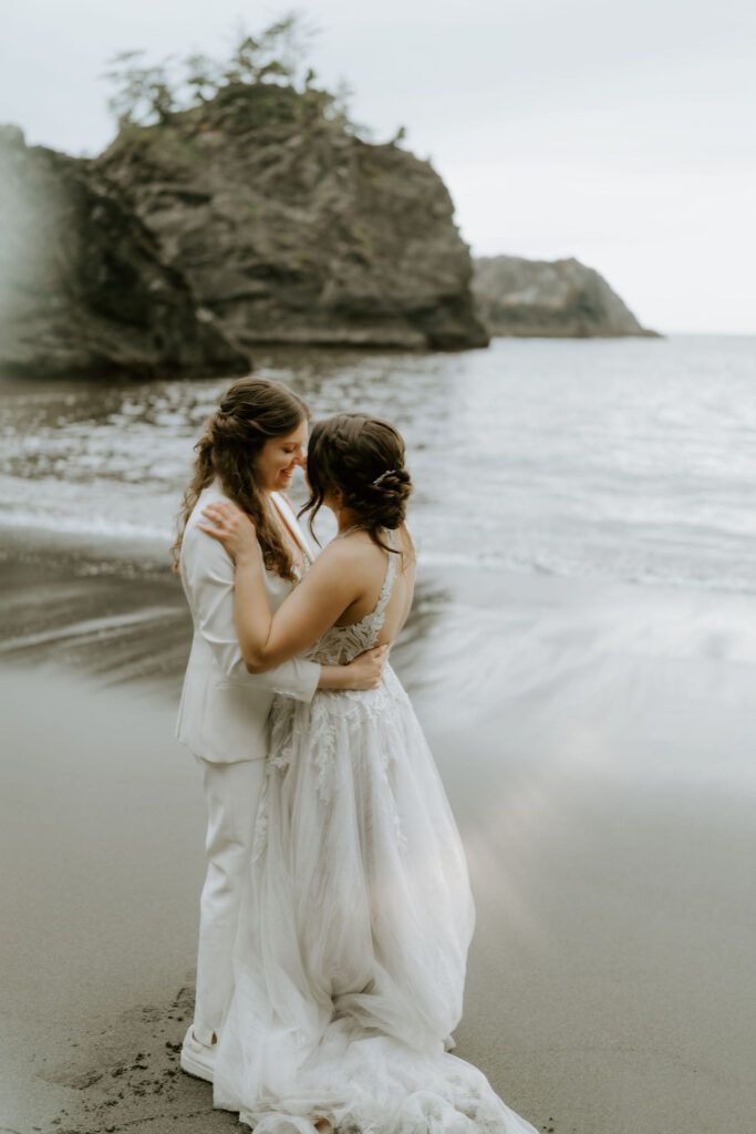 romantic elopement couple hugging at secret beach, oregon coast