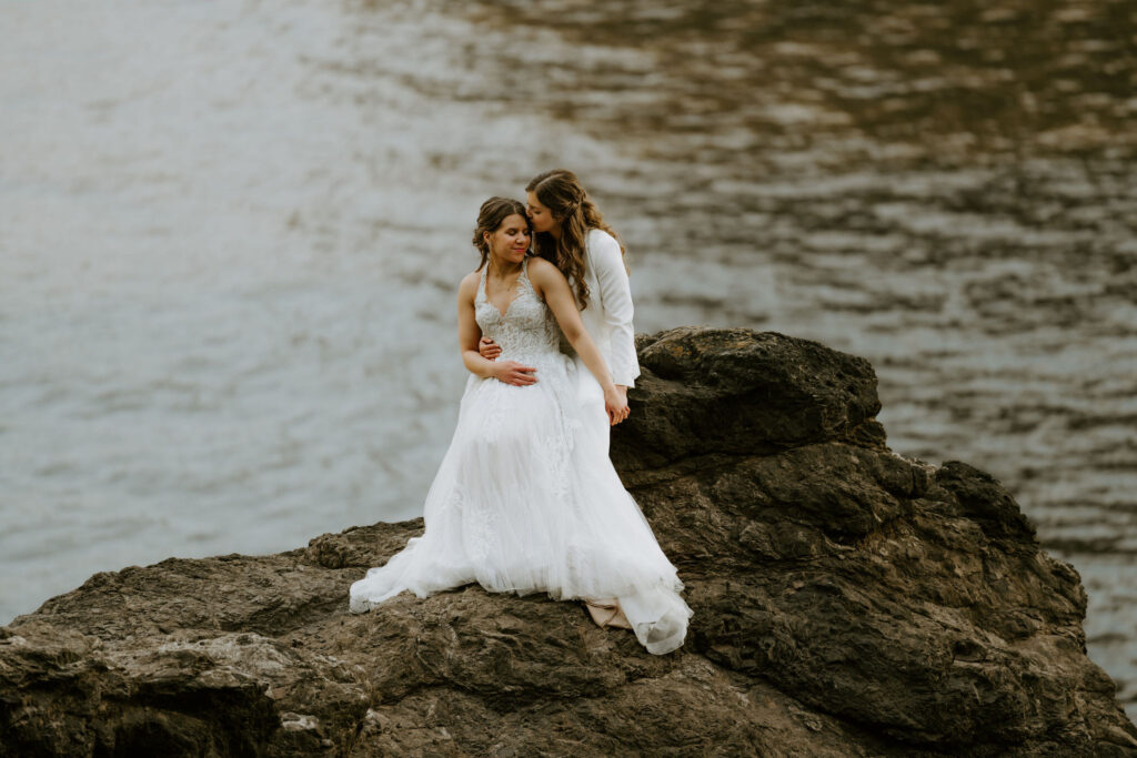 romantic moment of brides on a cliff at oregon coast
