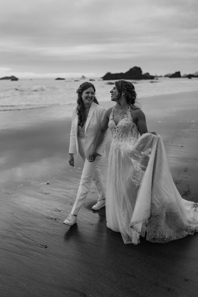 brides walking hand in hand around oregon coast at secret beach