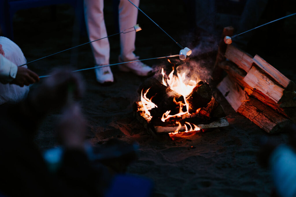 elopement couple enjoying a beach bonfire with family
