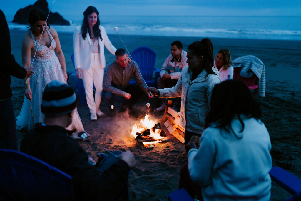 elopement couple enjoying a beach bonfire with family