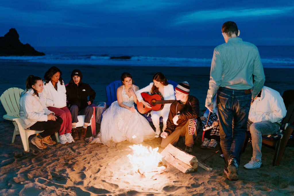 elopement couple enjoying a beach bonfire with family