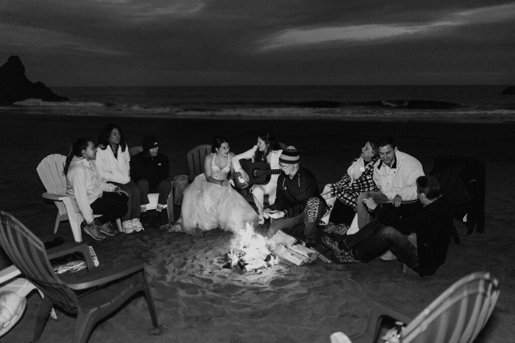 elopement couple enjoying a beach bonfire with family