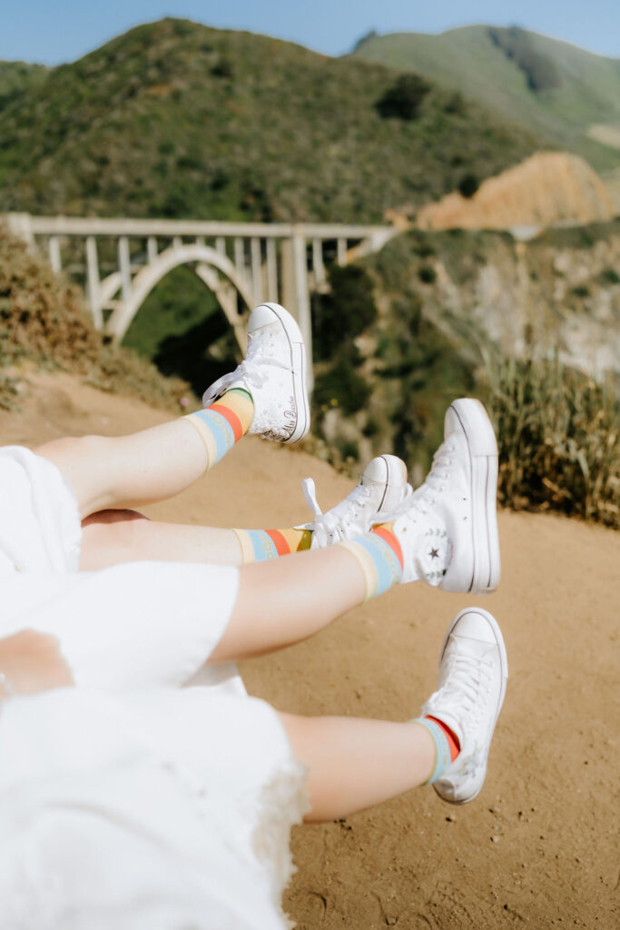 brides showing off their rainbow socks and white custom sneakers