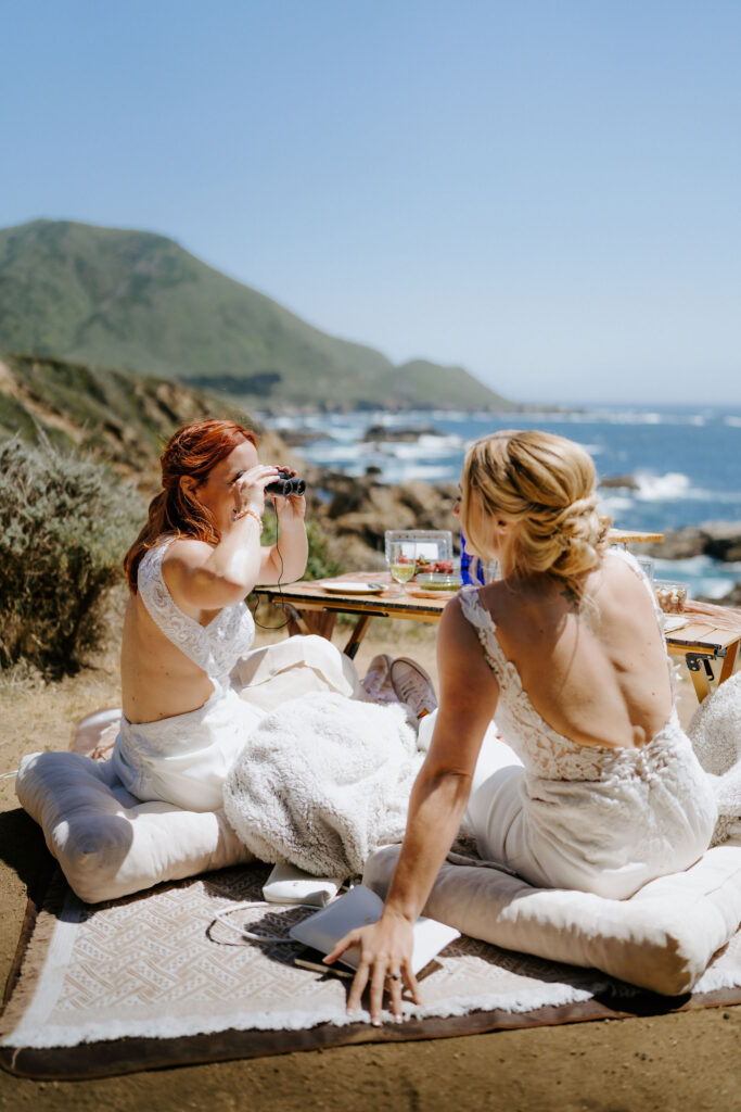 brides enjoying a luxury elopement picnic in big sur overlooking the ocean