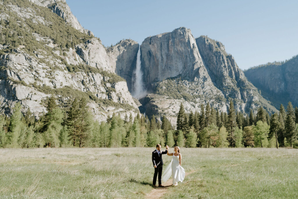 playful bride and groom walking through yosemite national park
