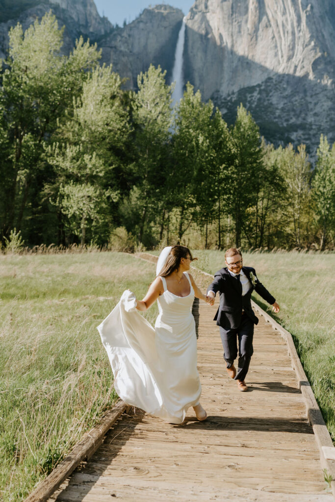 playful bride and groom running through yosemite national park