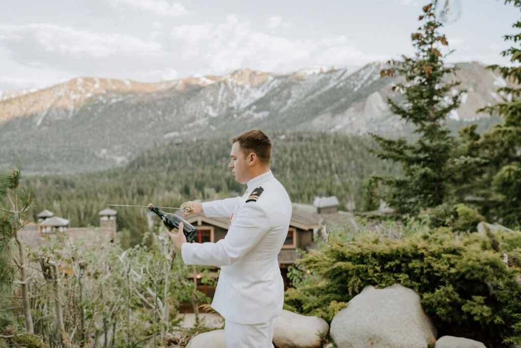 groom opening a bottle of champagne with a sword
