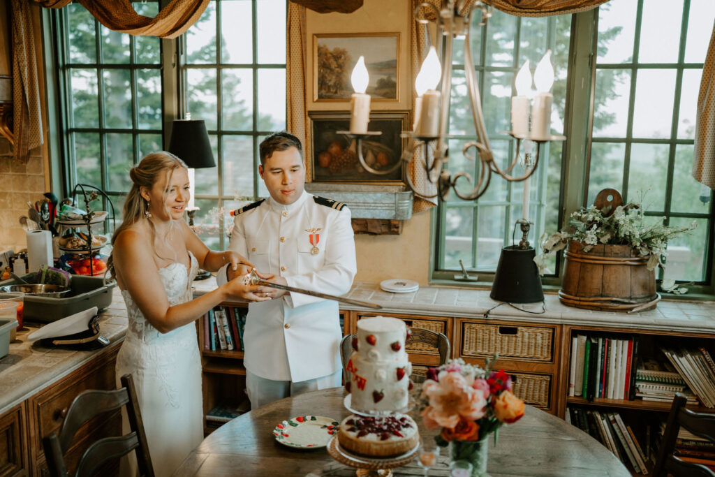 bride and groom cutting cake with a sword