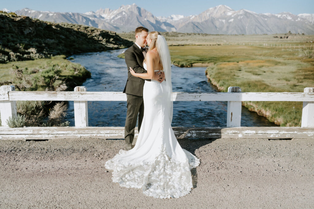 bride and groom hugging on a bridge at mammoth lakes