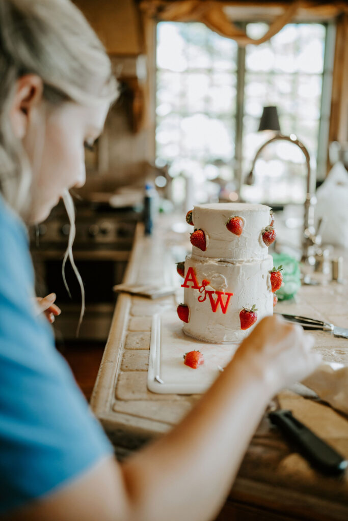 bride decorating a small elopement cake