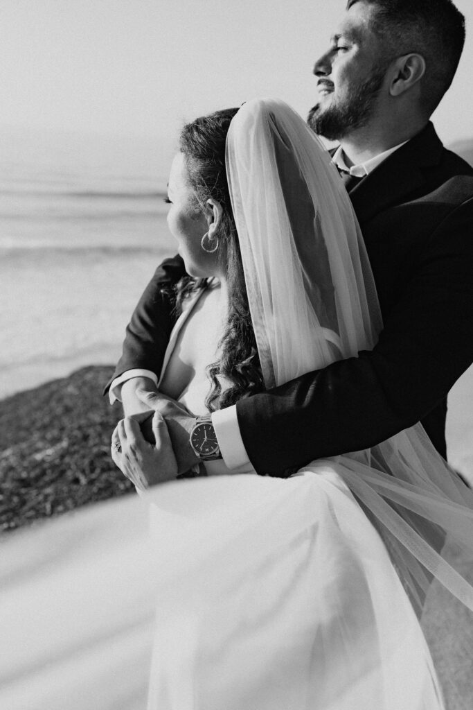 bride and groom posing on the bluffs overlooking the ocean in garrapata state park