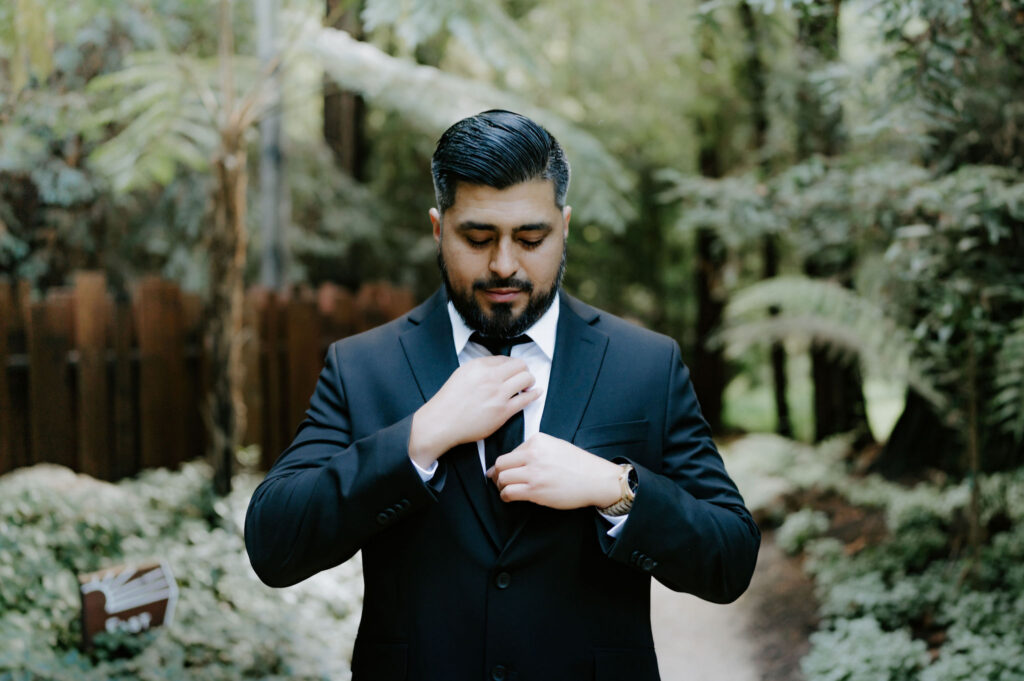 groom portrait by lush ferns during their Glen Oaks Big Sur elopement