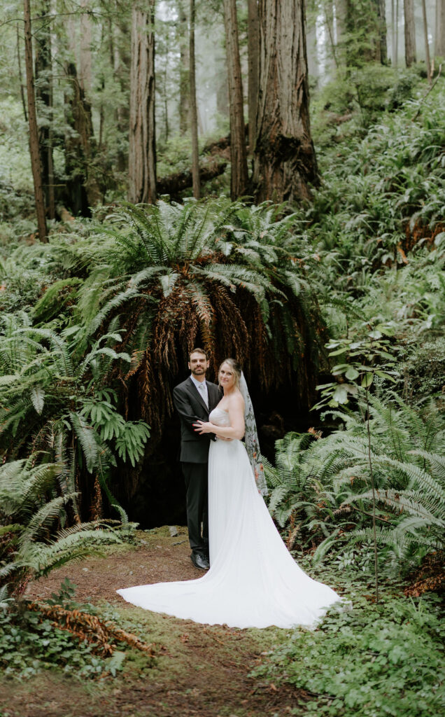 bride and groom surrounded by lush forest during their prairie creek redwoods elopement