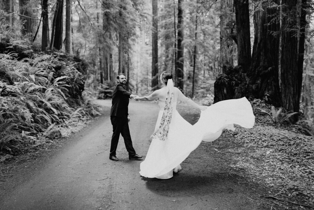 bride and groom hiking through the lush forest during their prairie creek redwoods elopement