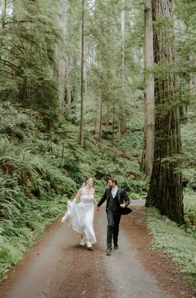 bride and groom hiking through the lush forest during their prairie creek redwoods elopement