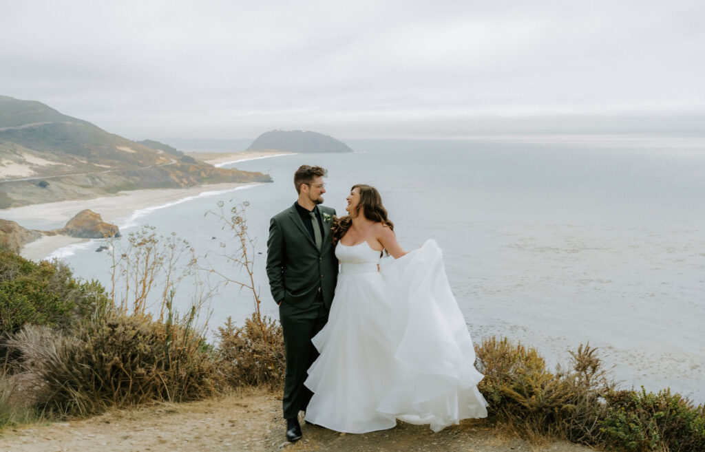bride and groom on a cliff in big sur overlooking the ocean