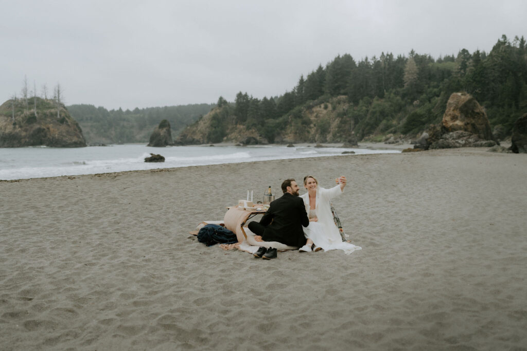 bride and groom sharing a picnic at the beach during their Trinidad State Beach elopement