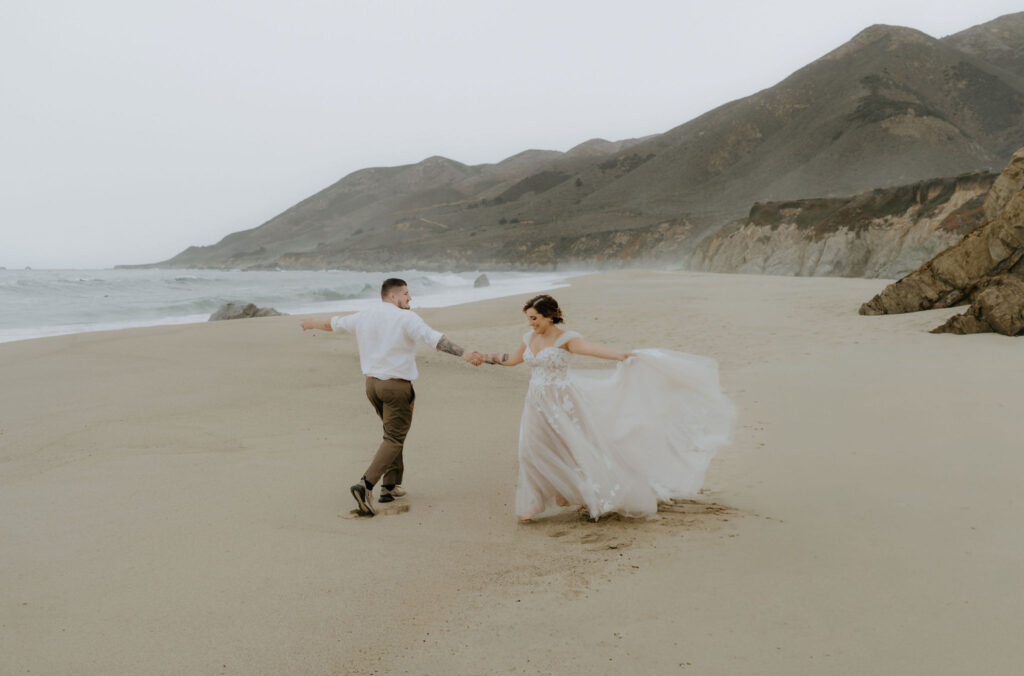 playful bride and groom at the beach shores at garrapata beach 