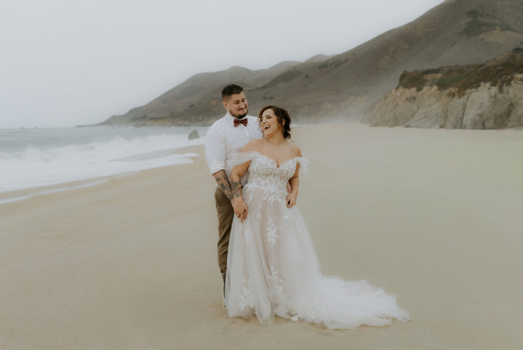 playful bride and groom at the beach shores at garrapata beach 