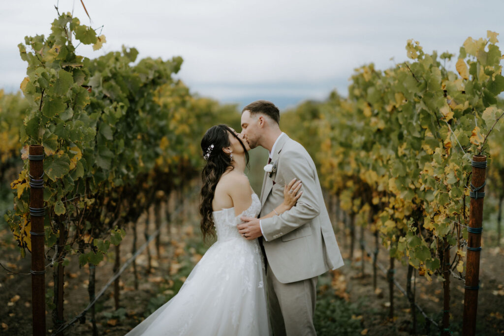 bride and groom kissing at a vineyard