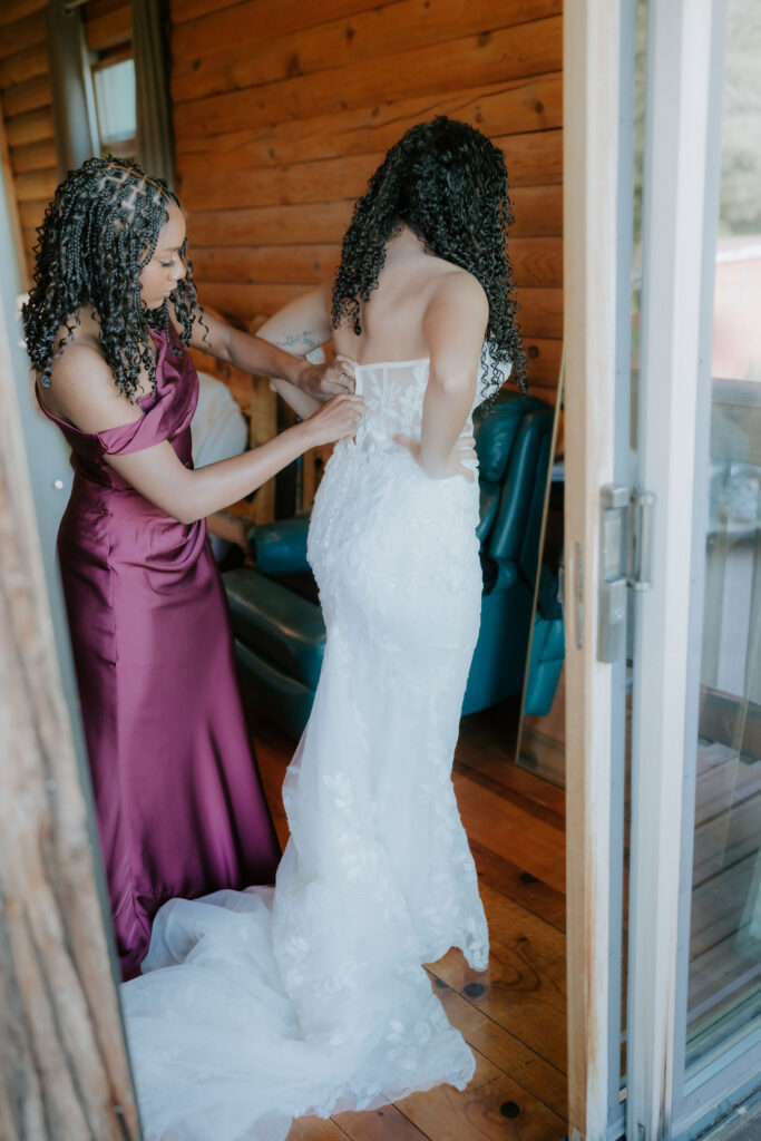 mother of the bride helping her with the wedding dress