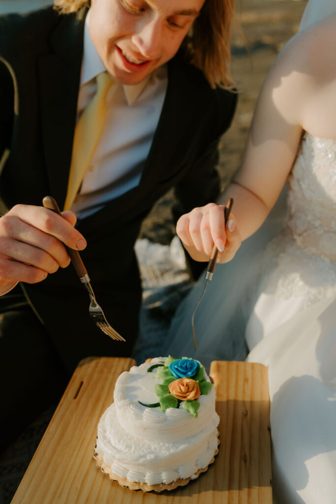Newly married couple trying their elopement cake