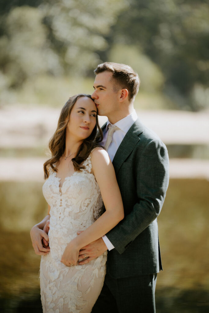 groom kissing the bride on the forehead