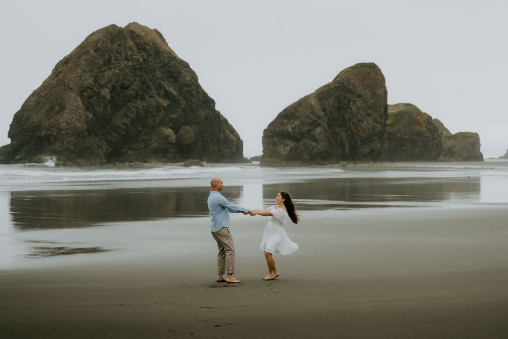cute picture of the newly engaged couple dancing at the beach