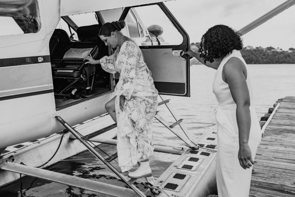 black and white elopement couple getting on seaplane