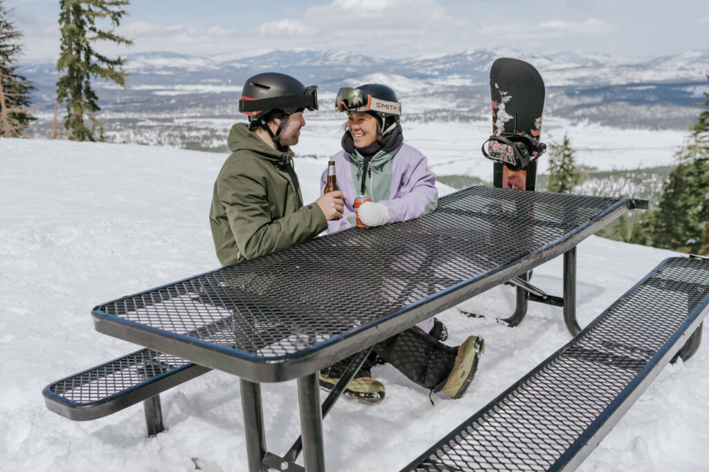 couple enjoying drinks at top of Northstar Lake Tahoe during engagement session