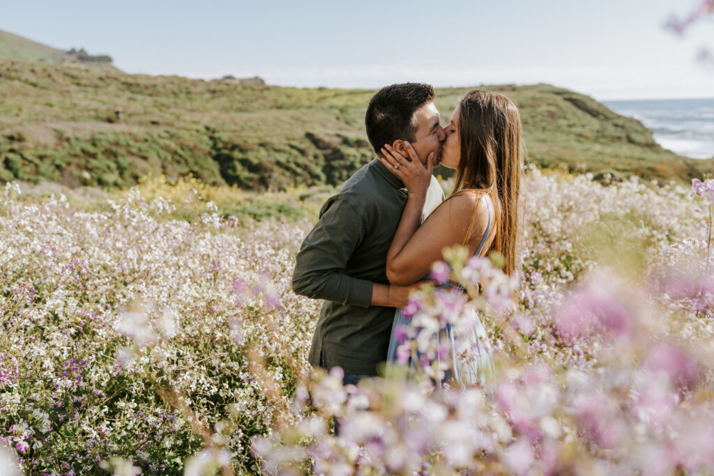 couple kissing in the wildflowers in big sur