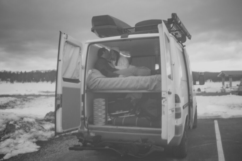 black and white image of adventure couple in their van during Lake Tahoe proposal