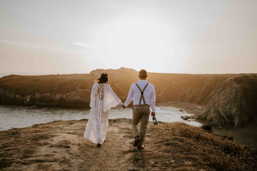 couple eloping in bodega bay walking the cliffs at sunset