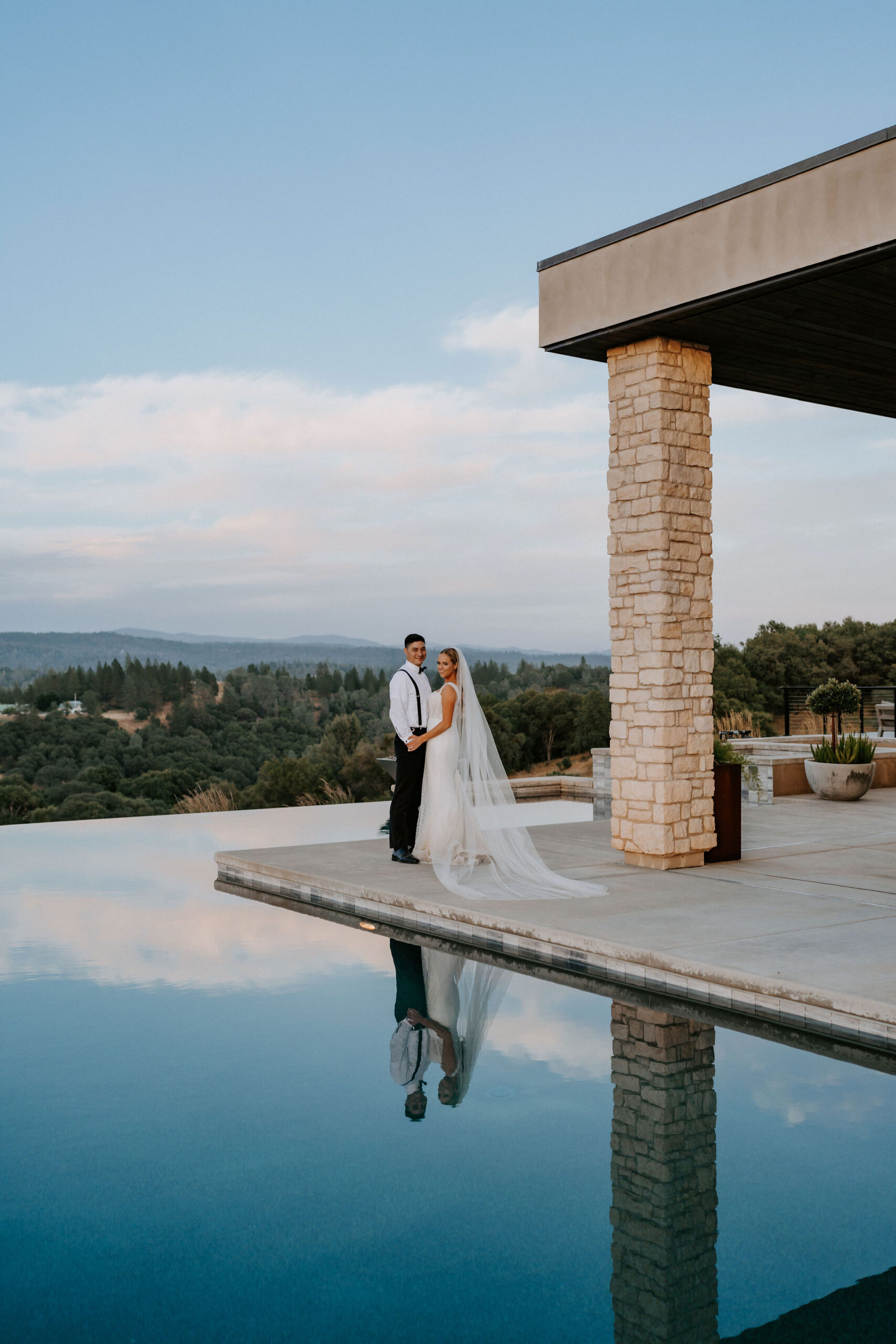 just married couple at black oak mountain vineyard wedding venue overlooking infinity pool at sunset